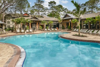 reclining lounge chairs surround outdoor swimming pool