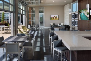 garage style glass doors open and enclose patio with bar, mounted tv and seating areas