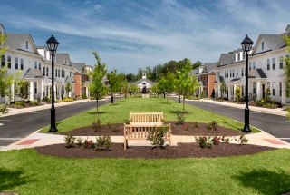 park bench on well manicured lawn in the middle of apartment community