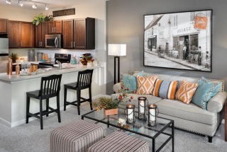 bright carpeted living room adjacent to kitchen